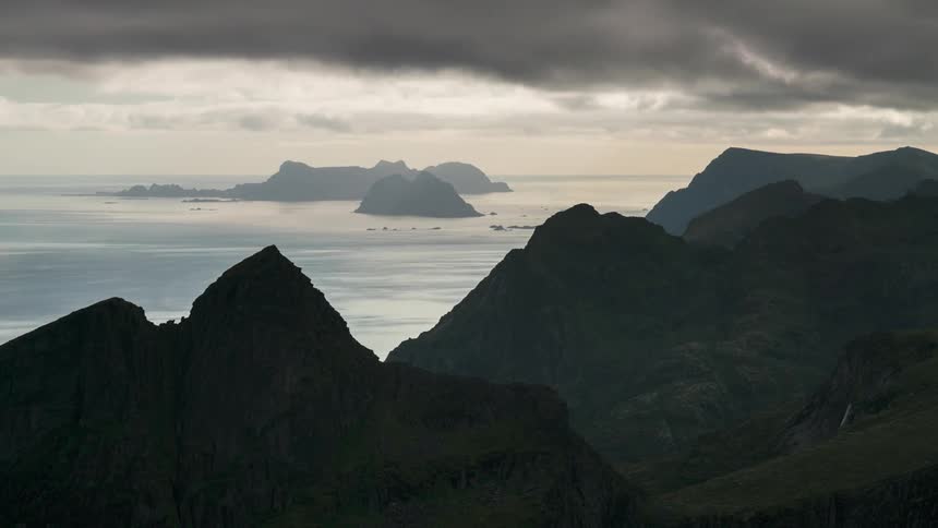 Time lapse of clouds rolling over mountainous islands at dusk