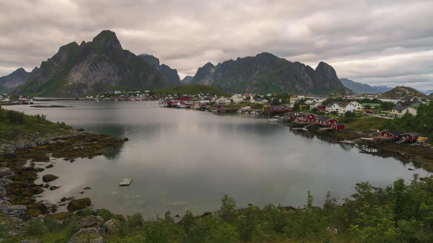 A small coastal community near tall mountains