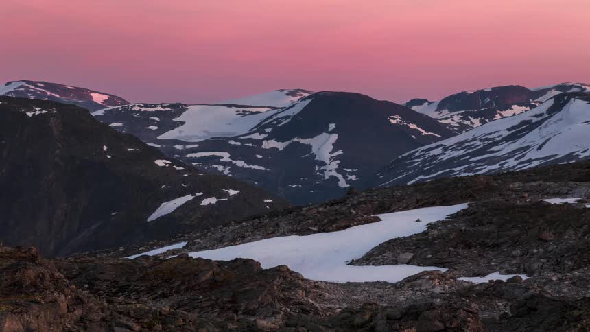 The sun is shining above the mountain range during the evening