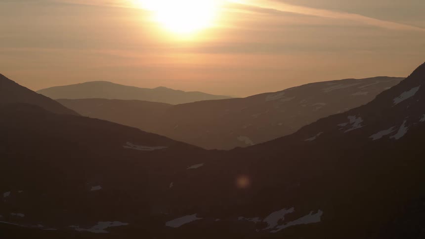 Snowy mountain range with sun rising and setting