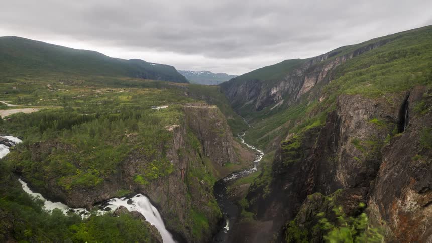Time lapse of a waterfall plunging into a river on a narrow valley in the mountains