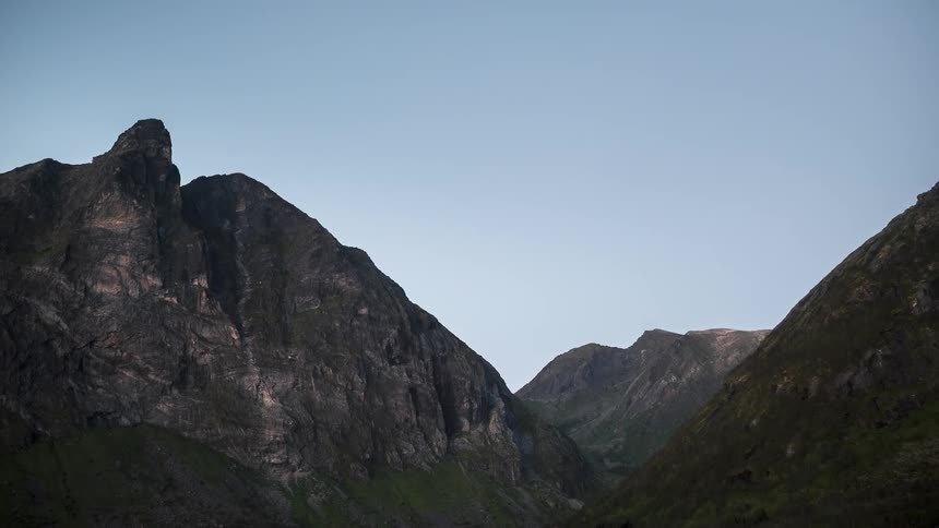 Rocky mountains against a clear sky in different tones
