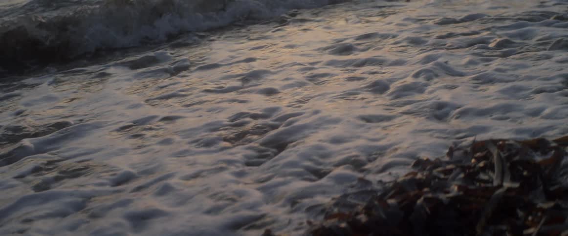 Ocean waves wash up onto a rocky beach