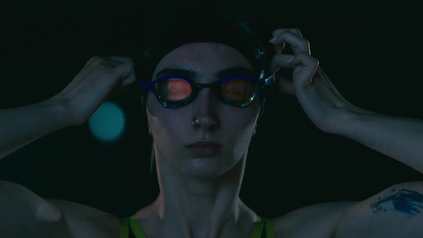 Woman putting on swimming goggles