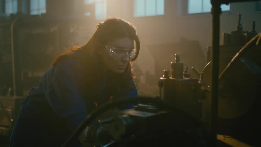Woman in front of a machine in a factory