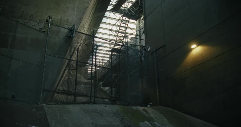 A light shines next to a fence blocking access to a construction site in a city