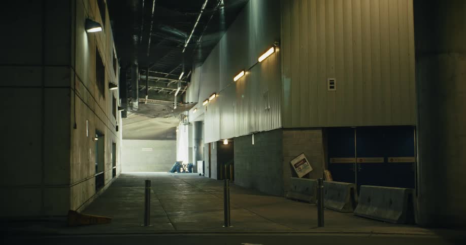 An empty factory with sunlight coming in through an open door at the back