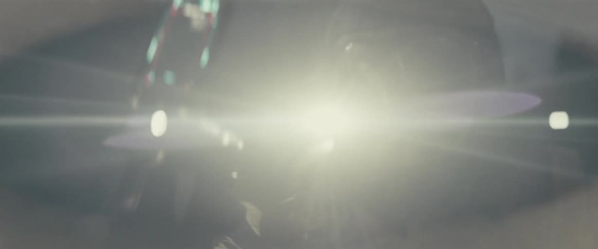 Close up of a man wearing a space suit with a shoulder mounted flashlight turning around