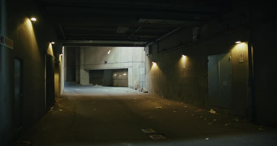 A city tunnel filled with trash and lit up by small lamps