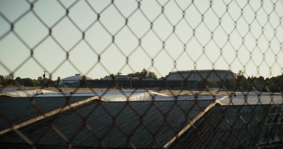 A view of a place with some structure roofs and there is a metal railing in front