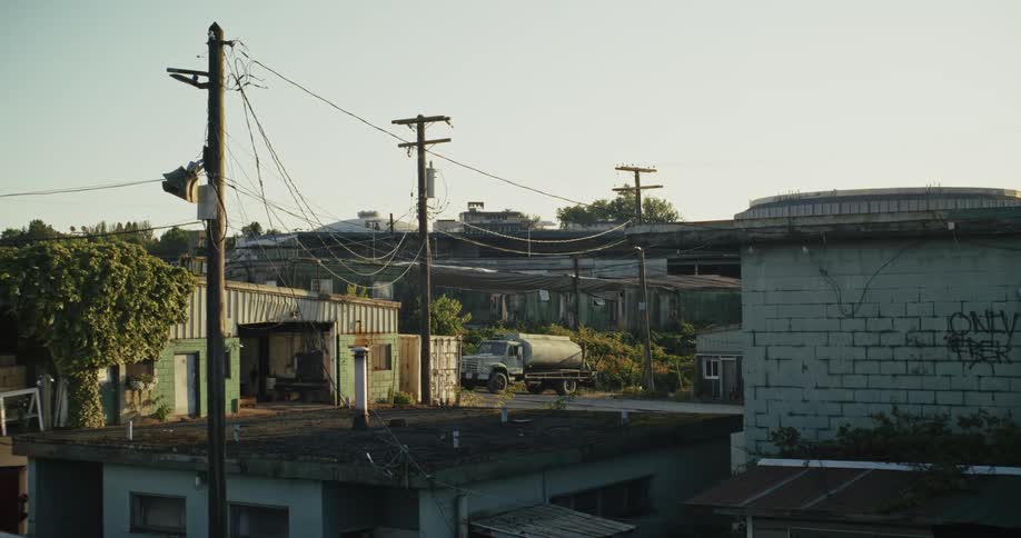 Water truck sits outside a shop in a sleepy industrial area
