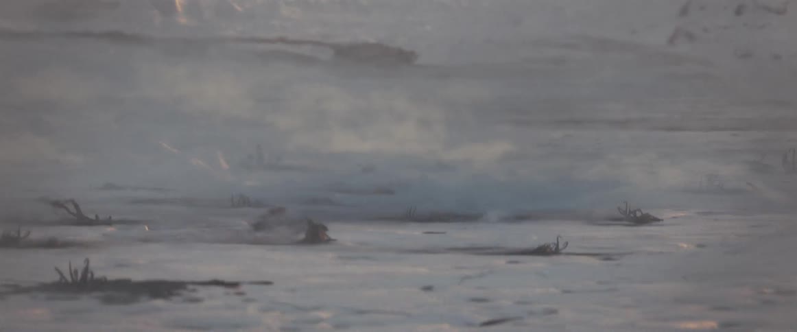 A closeup view of a snowcovered surface with burning remains still smoking
