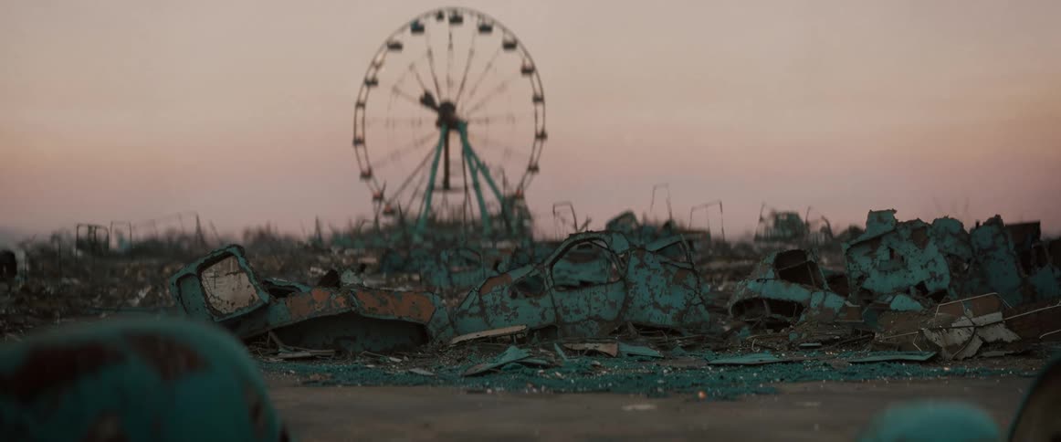 Only a ferris wheel stands untouched in a sprawling pile of rubble