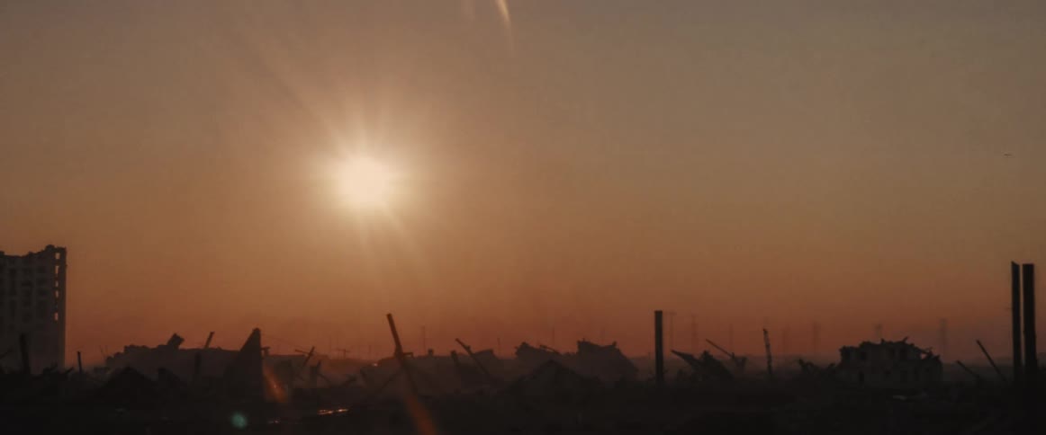 Sun sets over a pile of rubble that was once a city