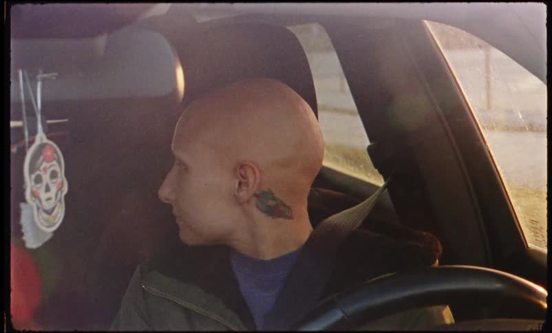 Bald woman driving a vehicle and then looking back
