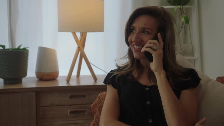 Woman having a converation on her cell phone while sitting on the couch