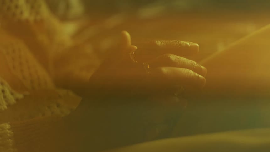 Pair of a persons hands with golden rings and the reflection of sunlight