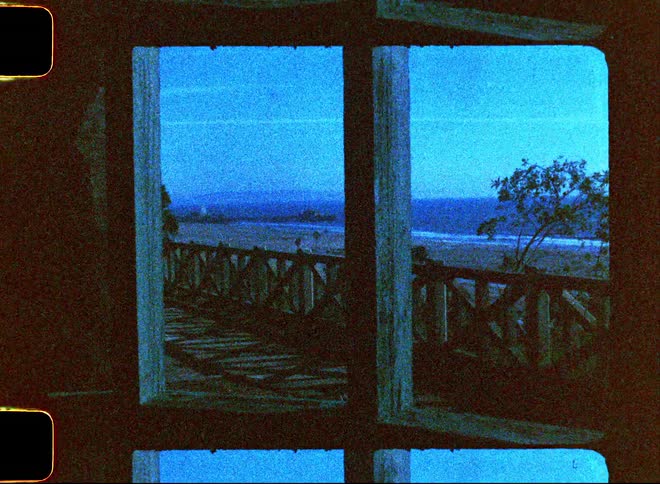 A beach seen through an open part of a house