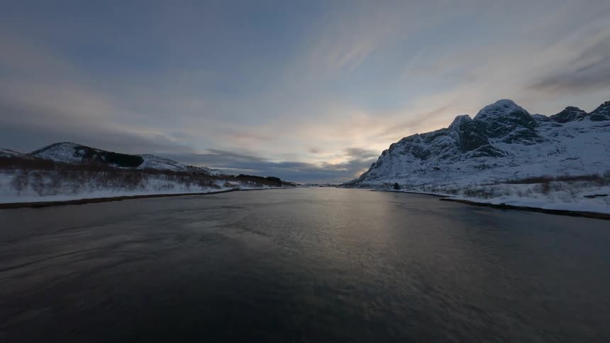 Natural landscape of a shipping channel surrounded by snowy mountains