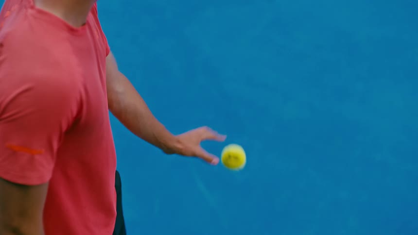 A tennis player chooses a ball and makes a serve on a court