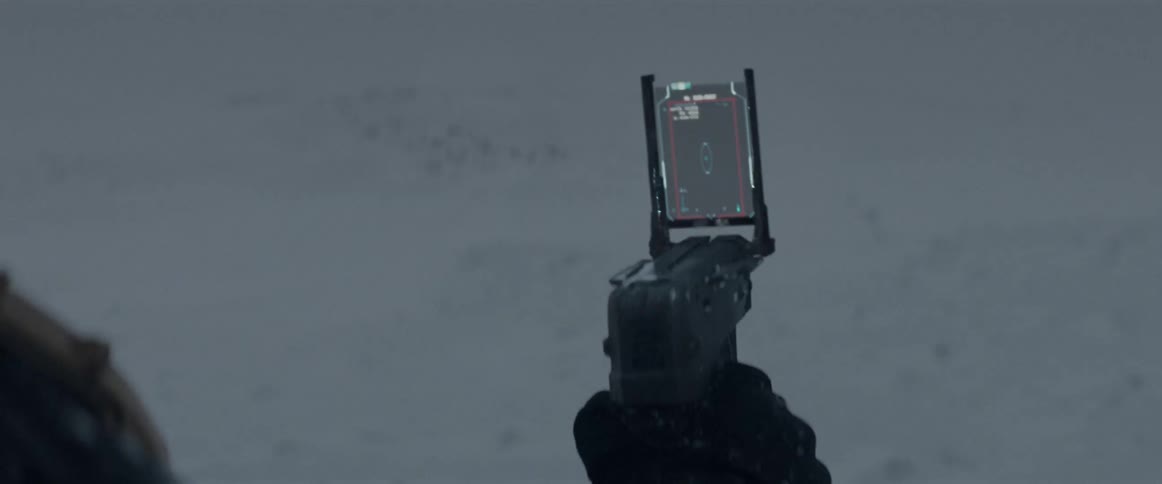 Camera with a futuristic attached monitor being held by a person in a snowy environment