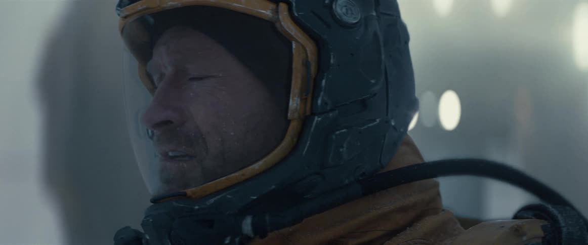 A man is wearing a protective suit and standing outdoors