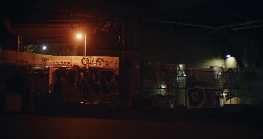 Train speeds by behind a chainlink fence with graffiti on it