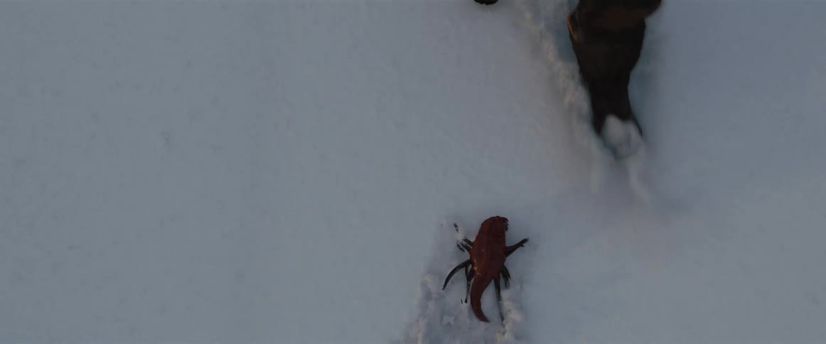 Person uses boot to push back small science fiction creature with tentacles