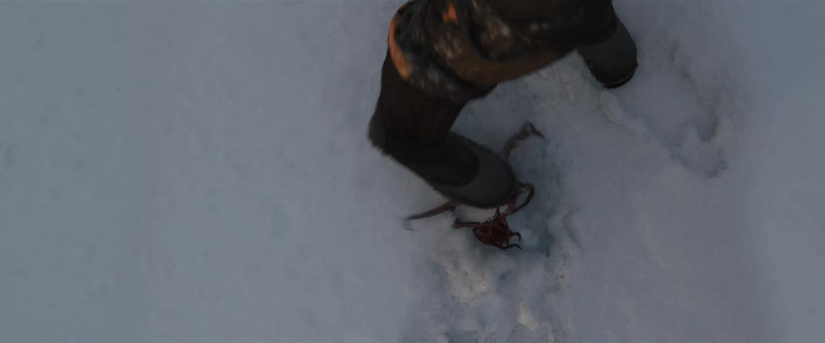 Man trampling an alien animal against the snowy ground