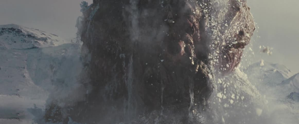 A giant alien creature emerges from beneath the ground