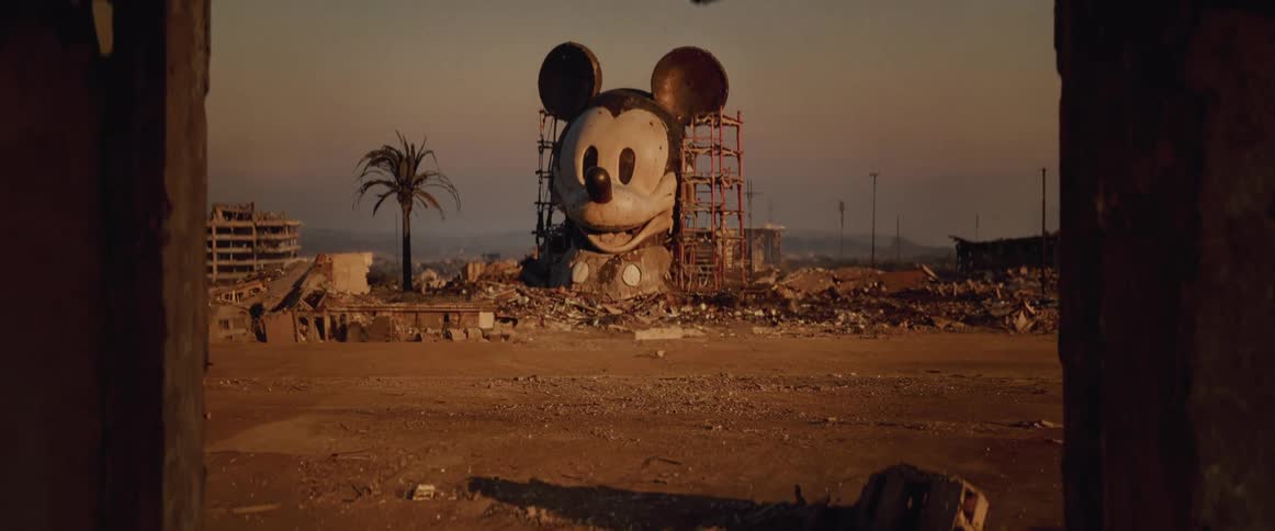 Large sculpture of mickey mouse in a state of deterioration located in an abandoned postapocalyptic lot