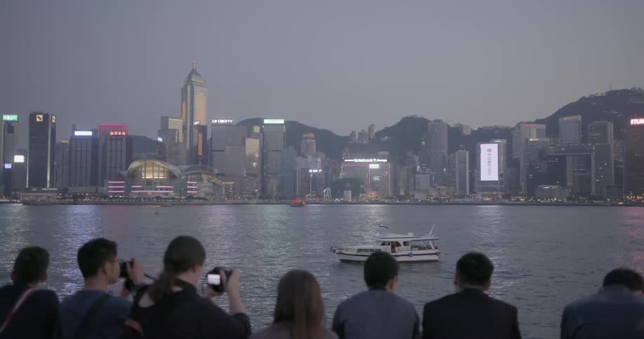 People photograph the hong kong skyline from across the bay