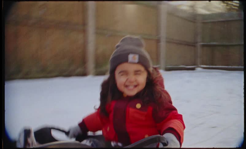 A child is sledding in their yard