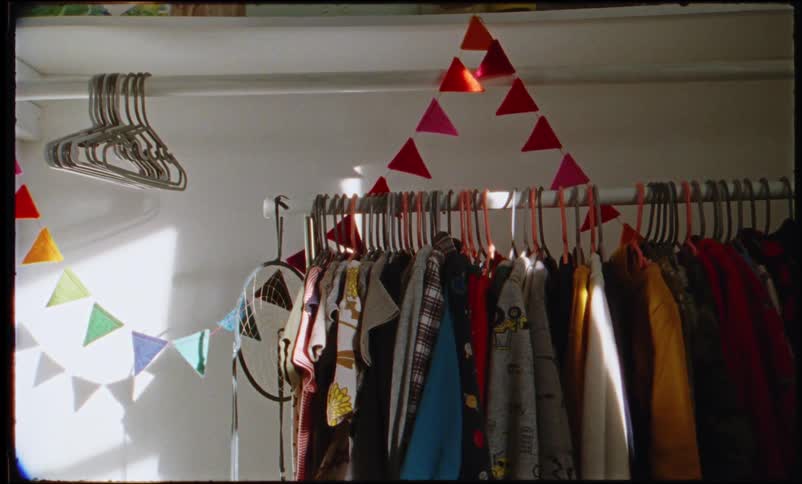 Banner of small flags hanging over clothes rack in the closet