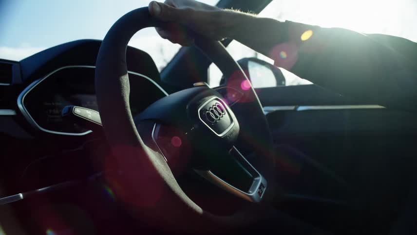A man drives a car with one hand