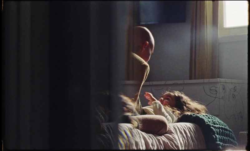 A bald woman playing with a little girl in the bedroom
