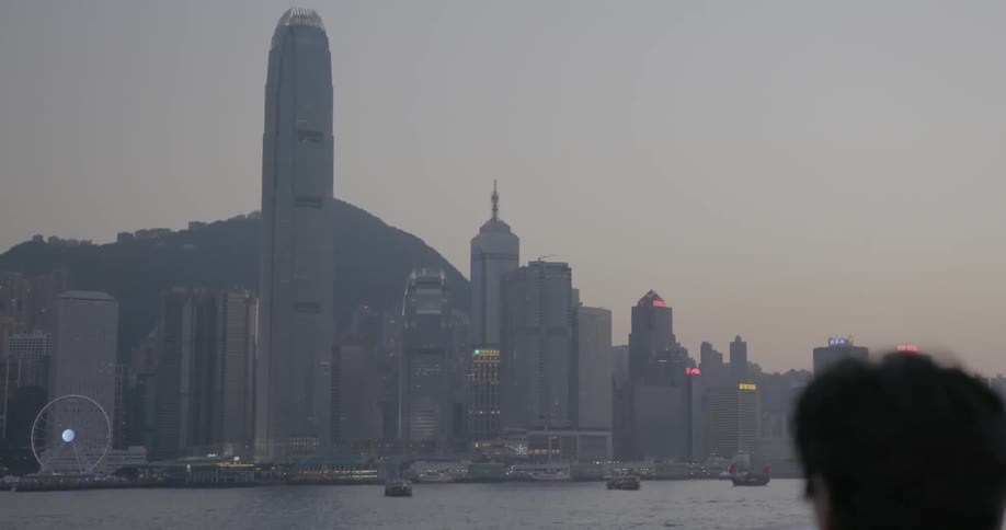 A person photographs the hong kong skyline on their smartphone