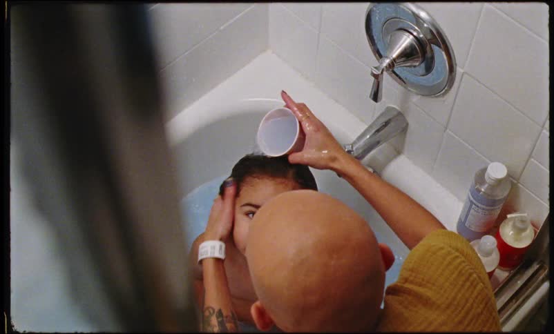 A mother helps her toddler take a bath