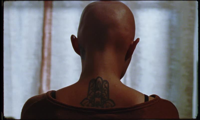 Back of a womans shaved head indoors