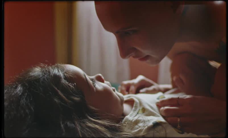A mother plays and laughs with her child in a room