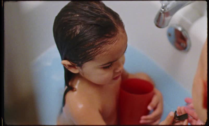 Mother bathing her little daughter in the bathtub