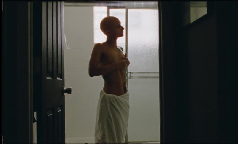 Woman applying cream to her body while in the bathroom