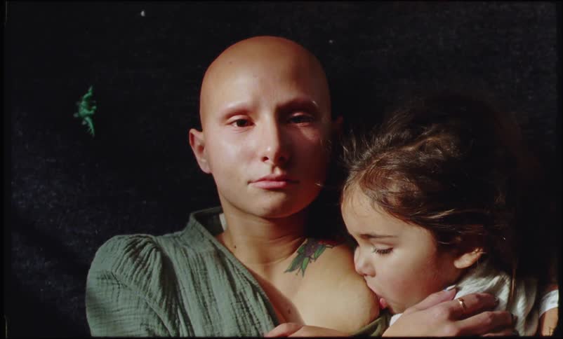 Close up of a bald tattooed woman breastfeeding her child