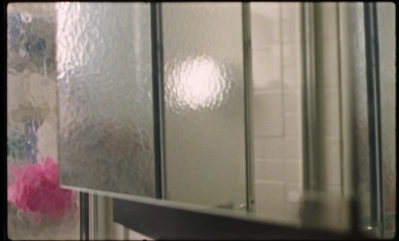 Bald woman taking towel and getting out of shower stall in bathroom