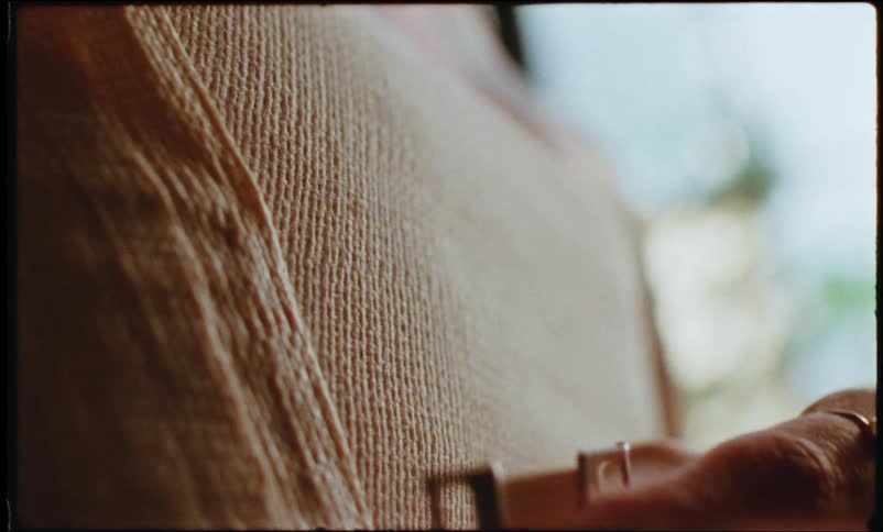 A human hand removing a clip from a garment