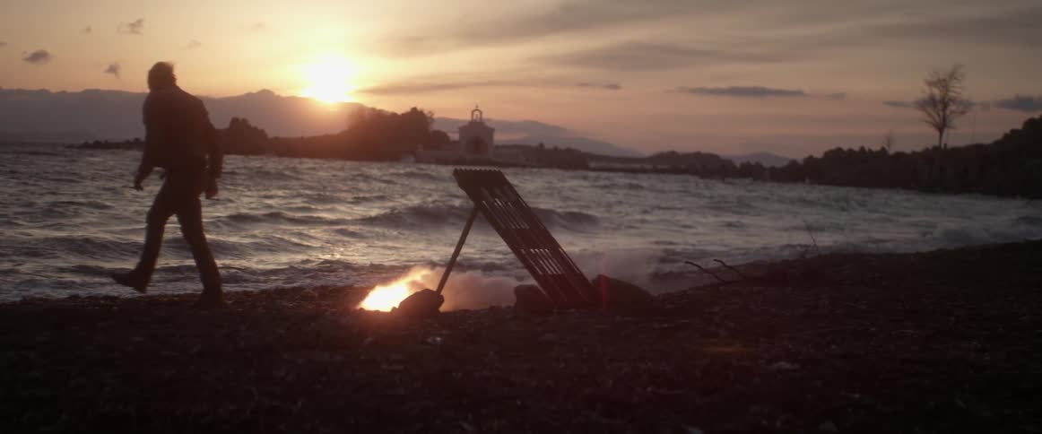 A man lights a firework on the beach
