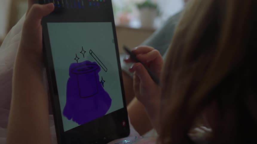 Girl holding a tablet and drawing with a pen