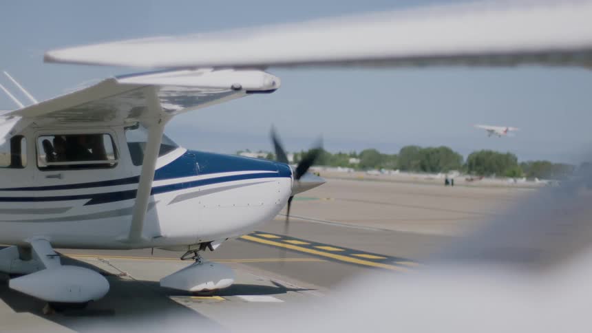 A planes propeller spins as it sits on the tarmac of an airport