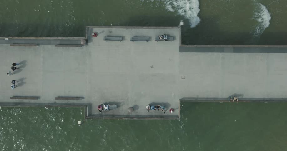 Birds eye view of people walking and relaxing on a pier at the beach