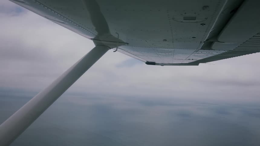Wing of an airplane as it soars in the cloudy sky